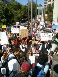 Protesters gather outside of Bank of America while one cuts up his debit card. (photo by Sitton)